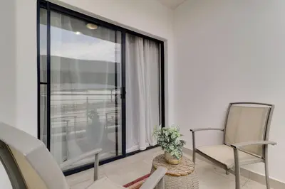 a living room with two chairs and a large window at Smartz Apartment312 in Midrand