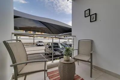 a balcony with two chairs and a car on a boat at Smartz Apartment312 in Midrand