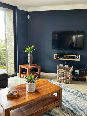 a living room with a tv and a coffee table at Waterfall House in Dullstroom