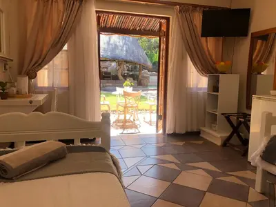 a bedroom with a bed and a door to a patio at Golf View Guest House in Musina
