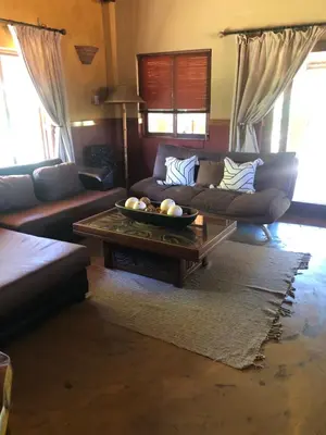 a living room with a couch and a coffee table at Golf View Guest House in Musina