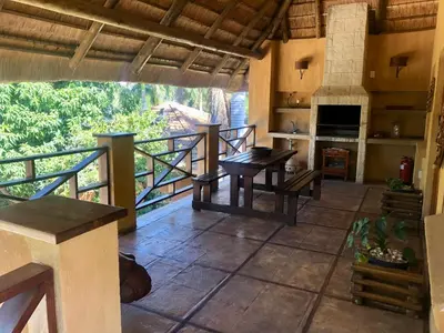 a kitchen with wooden tables and a balcony at Golf View Guest House in Musina