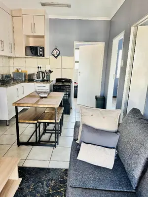 a living room with a couch and a table at Charming Wallet Friendly Apartment in Polokwane