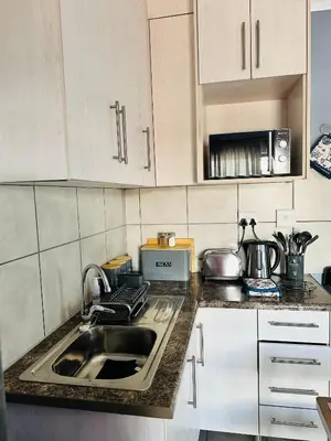 a kitchen with a sink and a counter top at Charming Wallet Friendly Apartment in Polokwane