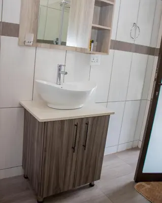 a bathroom with a white sink and a mirror at Boeketlong Lodge in Jane Furse