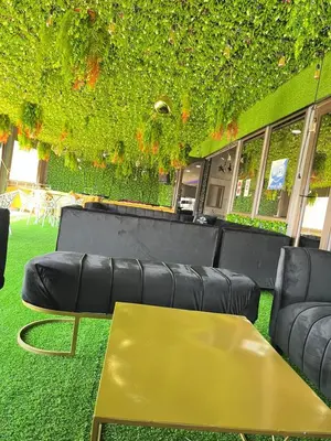a living room with black leather furniture and a yellow table at Boeketlong Lodge in Jane Furse