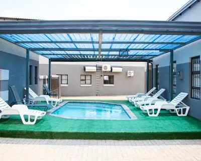 a pool with chaise lounge chairs and a swimming pool at Boeketlong Lodge in Jane Furse