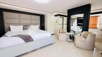 a bedroom with a large white bed and two chairs at Boeketlong Lodge in Jane Furse