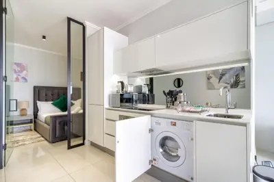 a white kitchen with a washer and dryer at AlimamaSpaces The Moksit Suite Ellipse in Midrand
