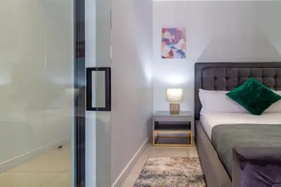 a bedroom with a bed and a glass door at AlimamaSpaces The Moksit Suite Ellipse in Midrand