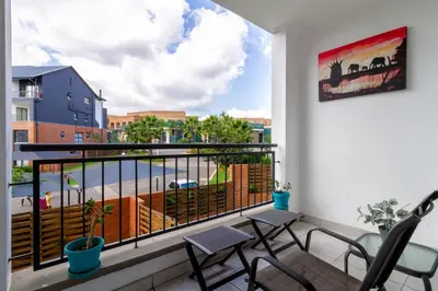 a balcony with chairs and a view of a street at Lovely 2 bed @TheBlyde in Pretoria