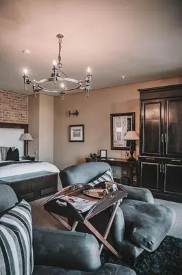 a bedroom with a bed and a table and chairs at Riboville Boutique Hotel And Restaurant in Midrand