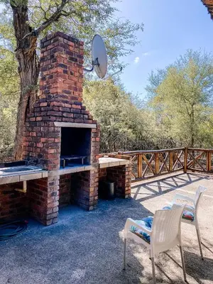 a brick oven with a table and two chairs at Escape@Butterfly in Marloth Park