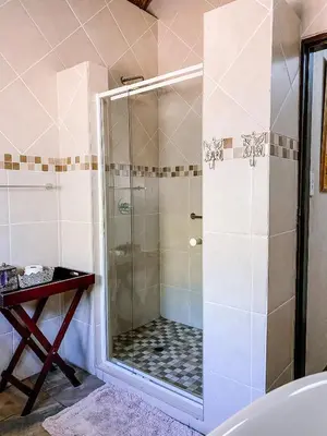 a shower with a glass door in a bathroom at Escape@Butterfly in Marloth Park