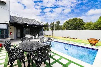 a patio with a table and chairs next to a swimming pool at Patimo Opulent Accommodation -Pretoria Mayville,Gezina in Pretoria