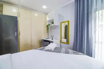 a bedroom with a large bed and a mirror at Patimo Opulent Accommodation -Pretoria Mayville,Gezina in Pretoria