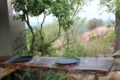 a wooden table with two plates on top of it at Luxury Treehouse on Bronberg Ridge in Tierpoort