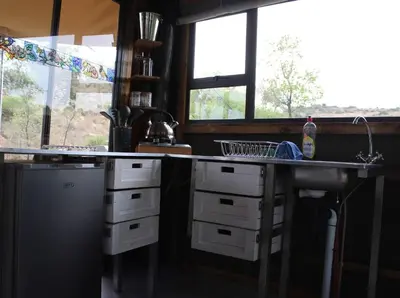 a kitchen with a sink and a counter with windows at Luxury Treehouse on Bronberg Ridge in Tierpoort
