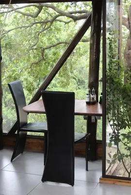 a table and chairs in front of a window at Luxury Treehouse on Bronberg Ridge in Tierpoort