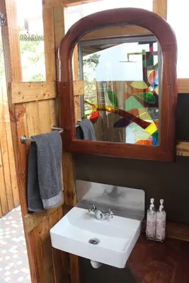 a bathroom with a sink and a mirror at Luxury Treehouse on Bronberg Ridge in Tierpoort