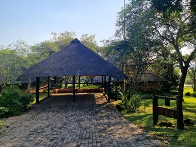 a pavilion with a blue umbrella in a park at Kruger Park Lodge - Private Villa 514 in Hazyview