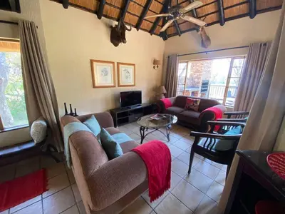 a living room with two couches and a table at Kruger Park Lodge - Private Villa 514 in Hazyview