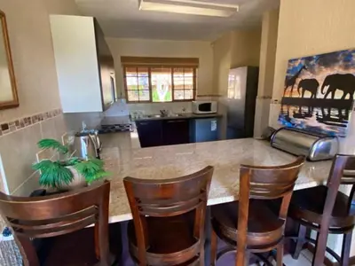 a kitchen with a island with chairs and a counter top at Kruger Park Lodge - Private Villa 514 in Hazyview