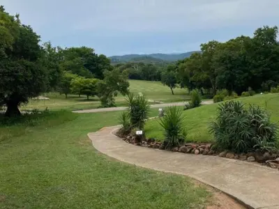 a winding path in a park with trees and grass at Kruger Park Lodge - Private Villa 514 in Hazyview
