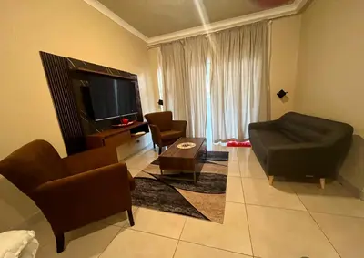 a living room with a couch and chairs and a television at THORNHILL ESTATE in Polokwane