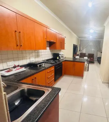 a kitchen with wooden cabinets and a sink at THORNHILL ESTATE in Polokwane