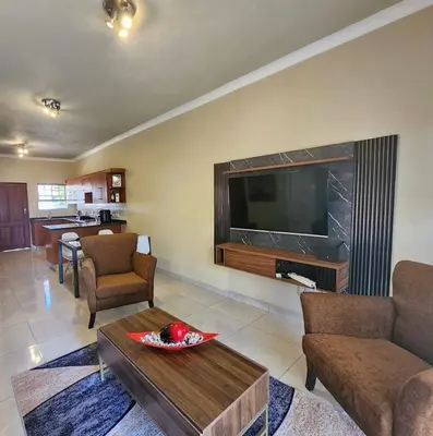 a living room with a large television and a table at THORNHILL ESTATE in Polokwane
