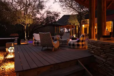 a deck with chairs and tables on a house at Villa Kudu - Exclusive and Serviced Safari Villa near Kruger Park in Hoedspruit
