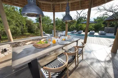a table with a bowl of fruit on a patio at Villa Kudu - Exclusive and Serviced Safari Villa near Kruger Park in Hoedspruit