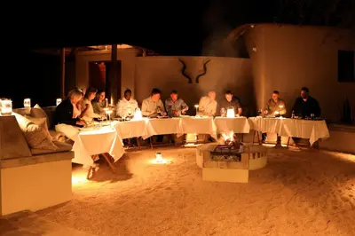 a group of people sitting at tables at night at Villa Kudu - Exclusive and Serviced Safari Villa near Kruger Park in Hoedspruit