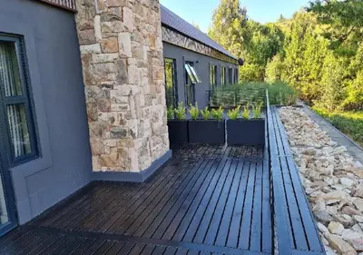 a deck with plants on the side of a building at Walkersons 96 - NinetySix on Valley View in Dullstroom