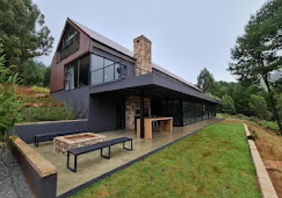 a house with benches in front of it at Walkersons 96 - NinetySix on Valley View in Dullstroom