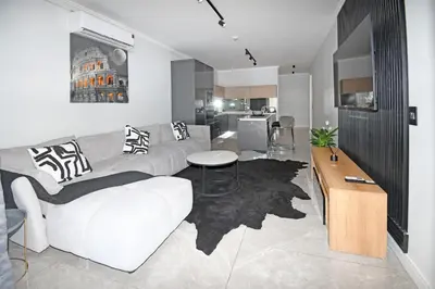 a living room with a couch and a table at Thango Res Ellipse Waterfall. in Midrand