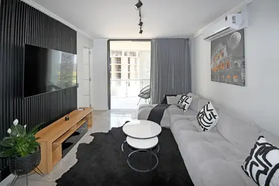 a living room with a couch and a tv at Thango Res Ellipse Waterfall. in Midrand
