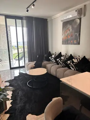 a living room with couches and tables and a large window at Thango Res Ellipse Waterfall. in Midrand