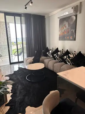 a living room with couches and a table and a rug at Thango Res Ellipse Waterfall. in Midrand