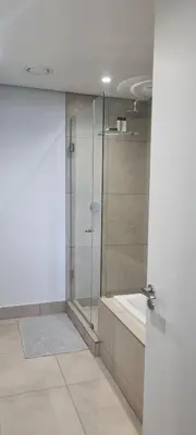 a bathroom with a glass shower and a tub at Ellipse Waterfall City Luxury Apartment - Bigger Apartment than Most - Middle floor in Midrand