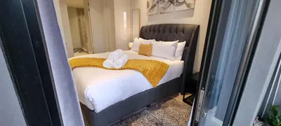 a bedroom with a bed with two towels on it at Ellipse Waterfall City Luxury Apartment - Bigger Apartment than Most - Middle floor in Midrand