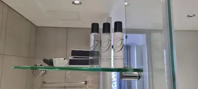 a glass shelf in a bathroom with some items at Ellipse Waterfall City Luxury Apartment - Bigger Apartment than Most - Middle floor in Midrand