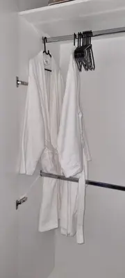 a white robe hanging on a rack in a closet at Ellipse Waterfall City Luxury Apartment - Bigger Apartment than Most - Middle floor in Midrand