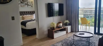 a bedroom with a bed and a tv on a wall at Ellipse Waterfall City Luxury Apartment - Bigger Apartment than Most - Middle floor in Midrand