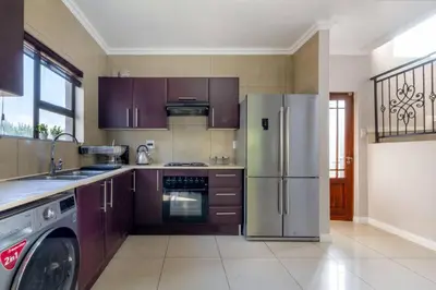 a kitchen with purple cabinets and a refrigerator at #AlimamaSpaces:The Lyndore Villa in Midrand