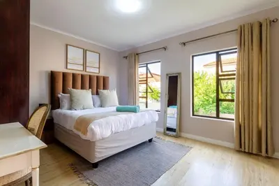 a bedroom with a bed and a large window at #AlimamaSpaces:The Lyndore Villa in Midrand