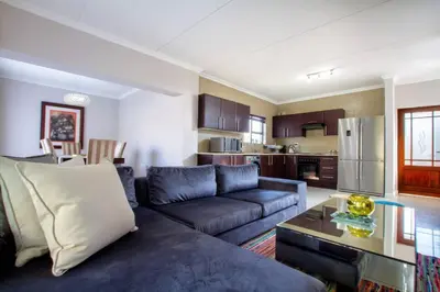 a living room with a blue couch and a kitchen at #AlimamaSpaces:The Lyndore Villa in Midrand
