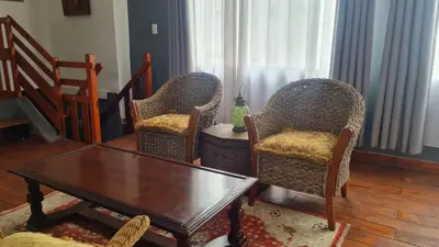 a living room with two chairs and a table at Gadute Haven - Luxury Apartment in Pretoria