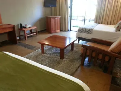a hotel room with a bed and a coffee table at eBundu Lodge in White River